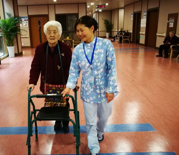 資料圖片：護(hù)理員正扶持老人進(jìn)行行走康復(fù)訓(xùn)練。新華社記者 董小紅 攝